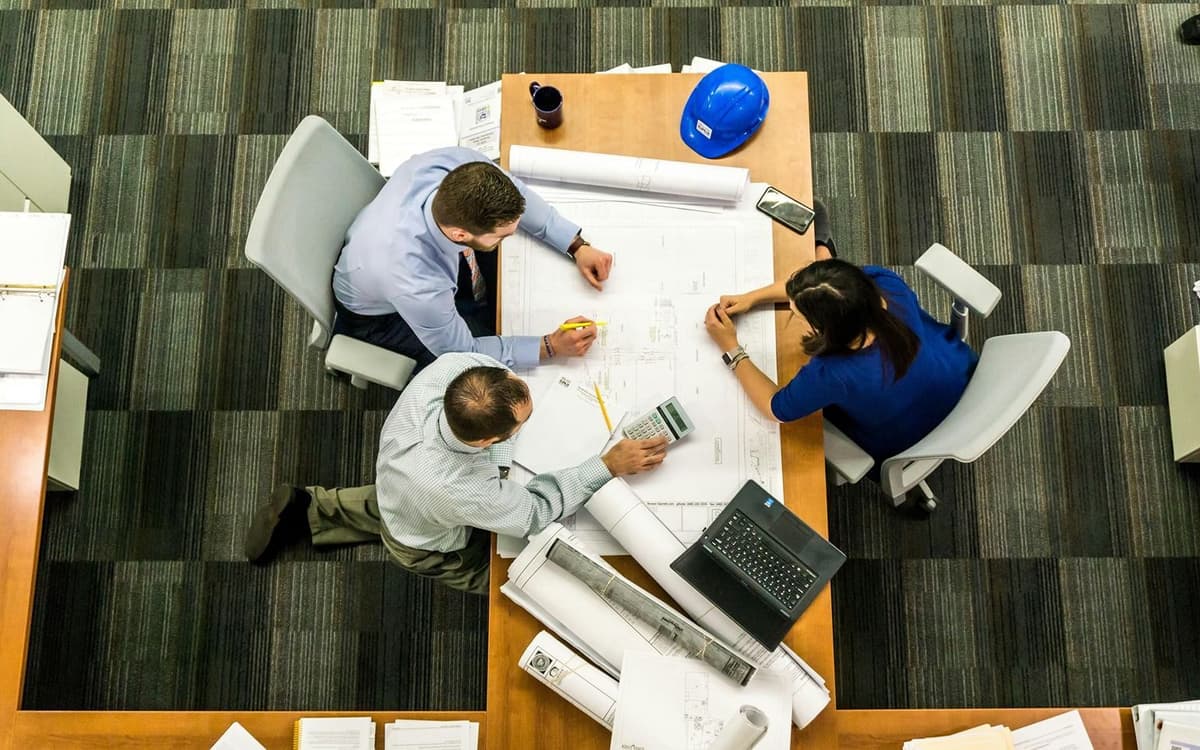 Top-down view of architect desk with digital twin technology plans and blueprints
